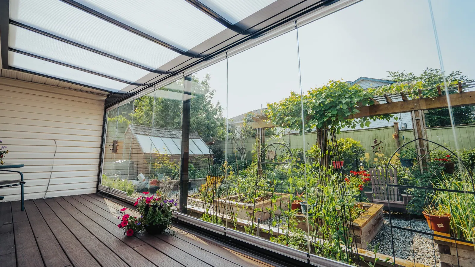 Lumon frameless glass enclosure opening a covered deck to a garden