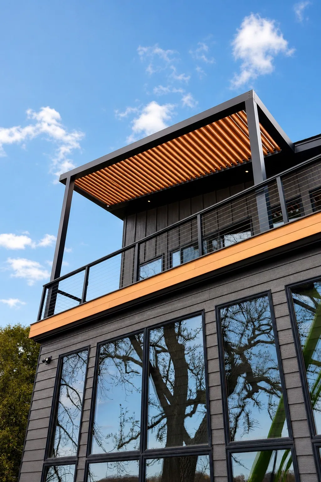 Rooftop louvered pergola with cedar-tone blades over a deck with cable railing