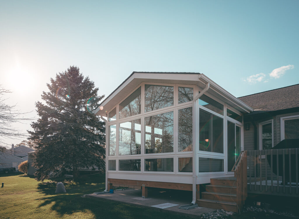 Sunroom seating area overlooking a wooded backyard